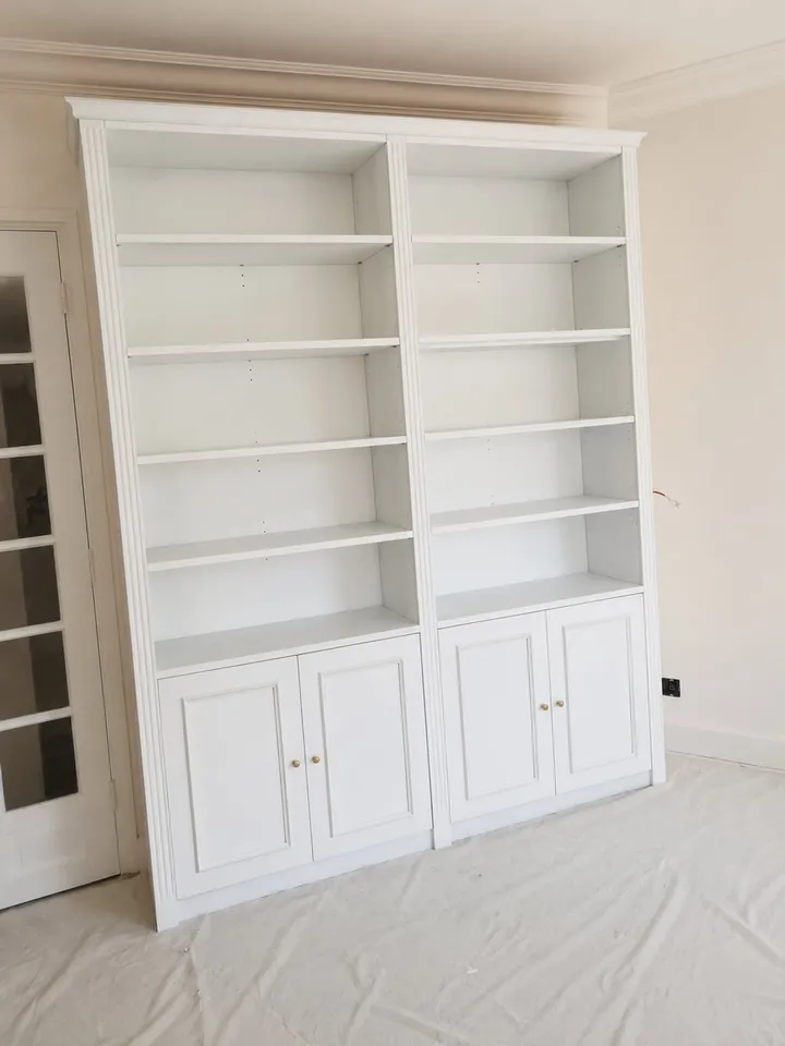 Bibliothèque sur mesure en bois peint, montants cannelés et portes basses à panneaux