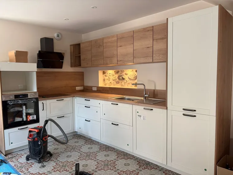 Cuisine sur mesure en bois et façades blanches, niche en pierre mise en lumière