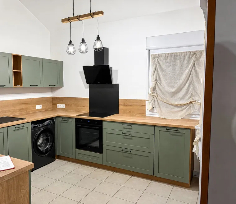 Cuisine sur mesure en L, façades vert olive, plan de travail bois et suspensions noires